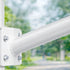 White metal railing with bolts against a blurred green outdoor background