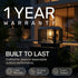Outdoor rectangular solar post light with a black frame and glowing warm bulb, mounted on a dark pedestal at night with large text reading '1 YEAR WARRANTY' and 'BUILT TO LAST' plus feature badges.