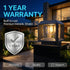 Outdoor solar lantern light fixture mounted on a black stone post in front of a modern house at night, with large text reading '1 YEAR WARRANTY' and a shield icon emphasizing built-to-last premium metallic shield quality.