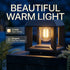A modern outdoor lantern-style light fixture with a glowing warm white filament bulb, shown lit at night on a stone surface with plants around it. Large text reads 'BEAUTIFUL WARM LIGHT,' and two callouts mention '2700K Warm White' and 'Elegant Filament Design.